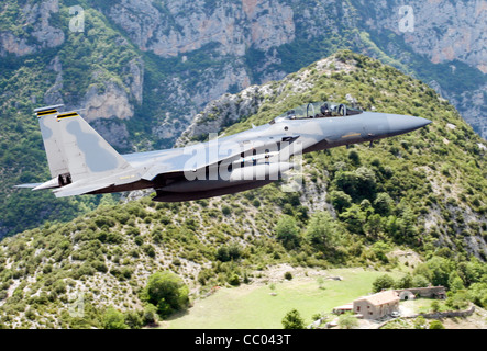 F-15 survolant un paysage de montagne Banque D'Images