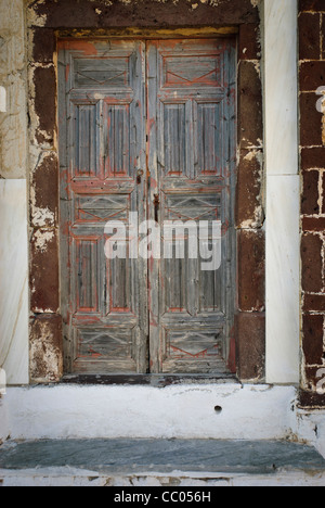 Une paire de portes ancienne en bois délabrée à Oia, Santorin, Grèce Banque D'Images