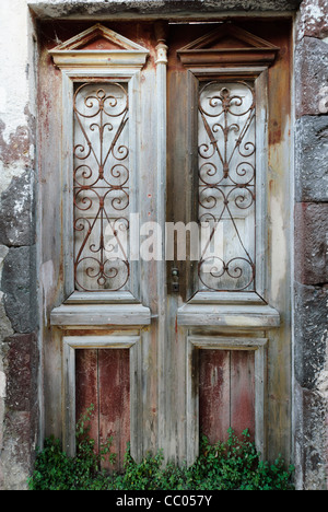 Une paire de portes ancienne en bois délabrée à Oia, Santorin, Grèce Banque D'Images