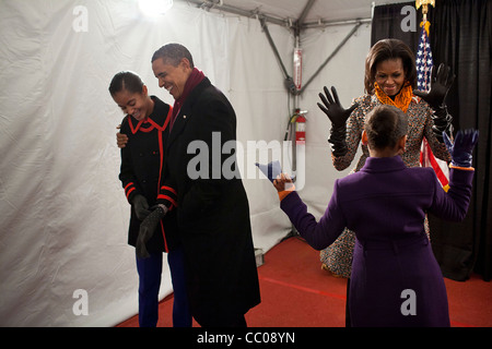 Le président Barack Obama hugs fille Malia en tant que première dame Michelle joue avec Sasha en coulisses avant l'allumage de l'arbre de Noël National à la Maison Blanche le 1 décembre 2011 à Washington, DC. Banque D'Images