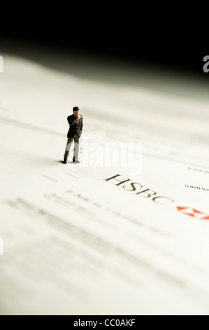 Une petite figure d'un homme regardant un relevé bancaire de la banque HSBC - image conceptuelle pour la banque et la finance Banque D'Images