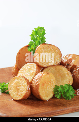 Rôties au four Pommes de terre sur une planche à découper Banque D'Images