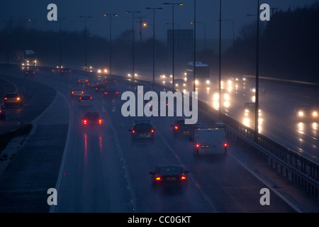 Les voitures et le trafic d'un soir de pluie humide sur l'autoroute britannique.La conduite dans des conditions hivernales dangereuses. Banque D'Images