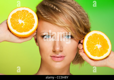 Les oranges juteuses et close-up shoot beauté d'une belle femme Banque D'Images