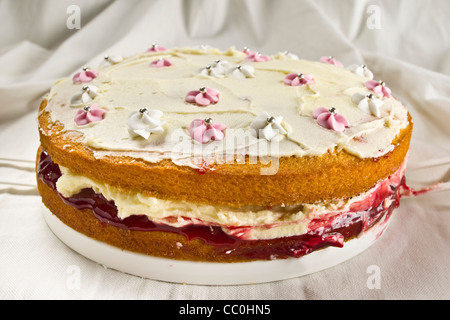 Gâteau éponge Victoria faits maison avec crème au beurre et confiture de framboises le remplissage. Banque D'Images