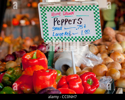 Poivrons rouges et oignons en vente à un marché au bord du chemin. Banque D'Images