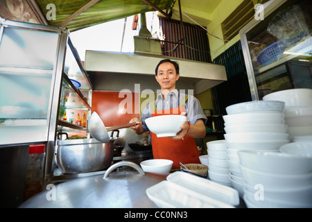 Chef de la préparation d'aliments de rue traditionnelle asiatique et de travail dans la cuisine du restaurant. De forme horizontale, front view Banque D'Images