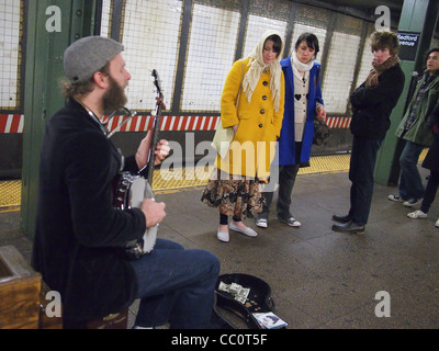 Musicien dans New York City subway joue du banjo comme d'autres l'écouter Banque D'Images