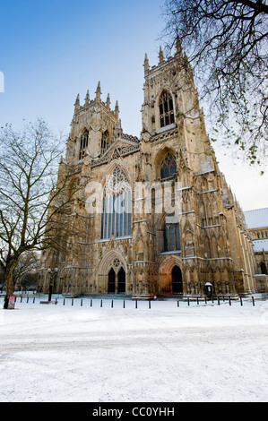 Entrée ouest de la cathédrale York Minster dans la neige entourée d'arbres. Banque D'Images