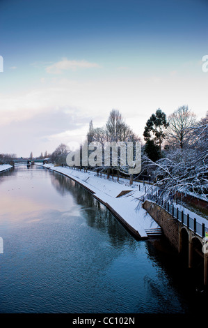 La neige couvrait Dame Judi Dench marchez le long de la rivière Ouse à York avec le pont ferroviaire de Scarborough au loin.Prise de vue depuis le pont Lendal. Banque D'Images