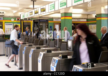 Les passagers utilisant les obstacles à un ticket gare d'Angleterre. Banque D'Images