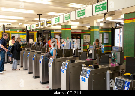 Les passagers utilisant les obstacles à un ticket gare d'Angleterre. Banque D'Images