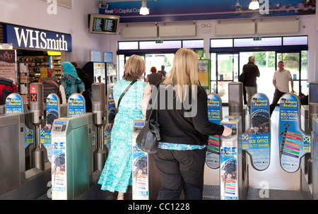 Les passagers utilisant les obstacles à un ticket gare d'Angleterre. Banque D'Images