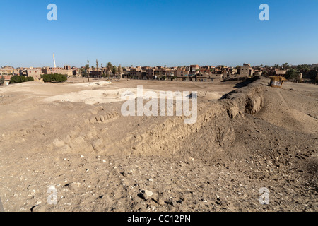 Les ruines de l'enceinte des murs et mound et moderne village en arrière-plan de Kom el Sultan à Abydos Moyenne Égypte Banque D'Images