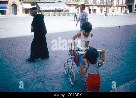 Un prêtre et d'enfants qui jouent sur la Piazza Navona Rome Italie Banque D'Images