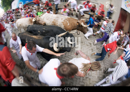 La foule courir avec les taureaux pendant le festival annuel de San Fermin (aka la course de taureaux à Pampelune, Espagne). Banque D'Images