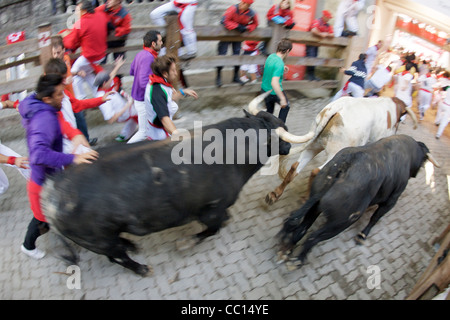 La foule courir avec les taureaux pendant le festival annuel de San Fermin (aka la course de taureaux à Pampelune, Espagne). Banque D'Images