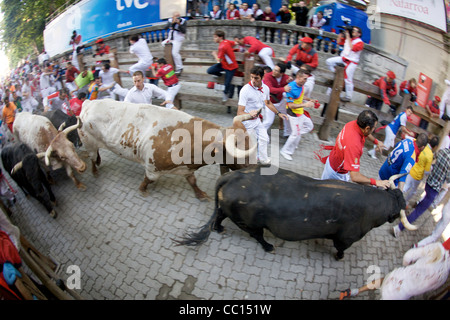 La foule courir avec les taureaux pendant le festival annuel de San Fermin (aka la course de taureaux à Pampelune, Espagne). Banque D'Images