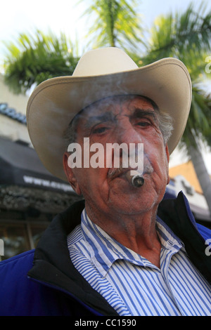 Un homme d'origine cubaine fume un cigare dans la Calle Ocho, Miami, Floride, janvier 2011. Banque D'Images