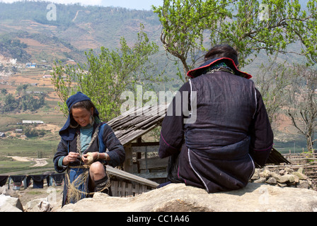 Deux femmes portant le costume traditionnel de la tribu H'Mong noir, une ficelle de filature Banque D'Images