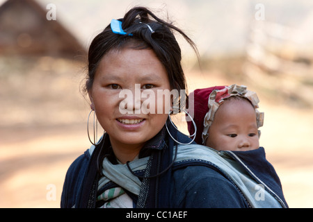 Jeune femme ou une jeune fille portant costume traditionnel de la tribu H'Mong noir portant un bébé sur son dos Banque D'Images