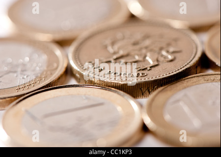Euros et en livres sterling à côté de l'autre sur la surface blanche Banque D'Images
