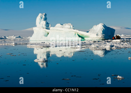 Zodiaque avec les touristes en croisière dans l'avant d'un iceberg, mer de Weddell, l'Antarctique Banque D'Images