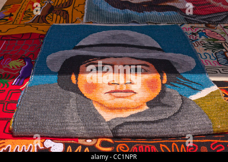 Un tapis tissé avec une conception d'un autochtone en vêtements traditionnels à Otavalo, Equateur. Banque D'Images