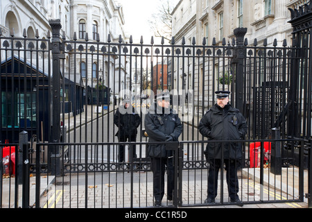 Les agents de protection armée de la police métropolitaine à l'extérieur de la porte de sécurité à Downing Street London England UK whitehall Banque D'Images