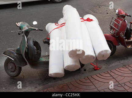 Scooter Vespa chargés de marchandises dans les rues de quartier de Chinatown à Bangkok Banque D'Images