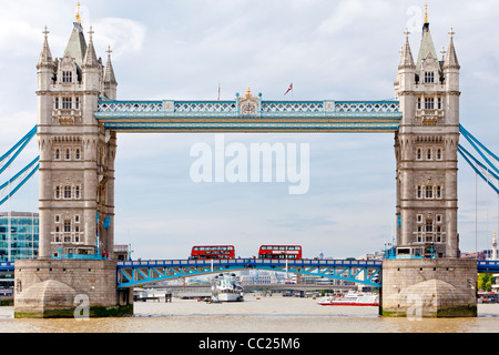 Les bateaux de croisière en prenant les touristes sur un trajet sur la rivière Thames et double decker bus traversant le Tower Bridge. Banque D'Images