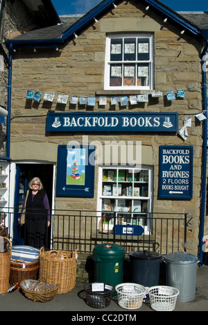 Femme debout sur le seuil d'une librairie à hay-on-Wye, la frontière galloise qui est devenu une ville booklovers' destination. Banque D'Images