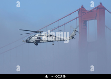 Un UH-60 de l'US Navy Sea Hawk vole près d'une des tours du pont Golden Gate. Banque D'Images