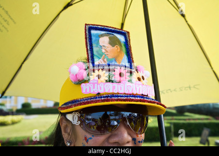 Woman wearing cap décoré avec une image du monarque, le Roi Bhumibol Adulyadej. Bangkok, Thaïlande Banque D'Images