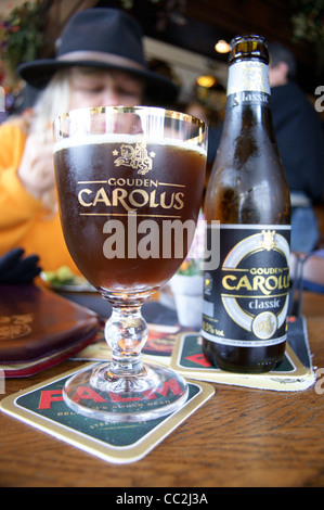 Une impression de verre de Gouden Carolus classic dark bière belge de la brasserie Het Anker, Antwerpia bar, café, Mechelen, Belgique, avec sa bouteille Banque D'Images