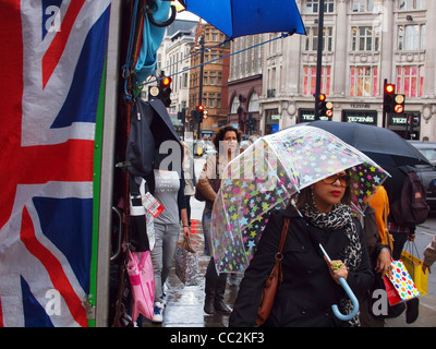 Shoppers on Oxford Street de Londres au cours d'une douche Banque D'Images