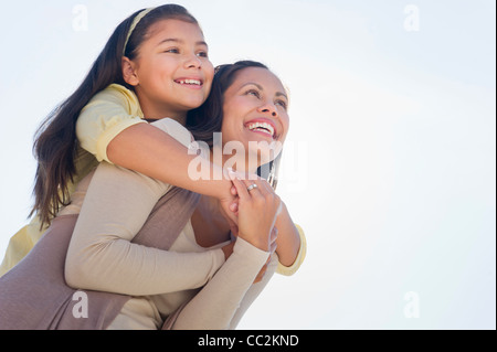 USA, New Jersey, Jersey City, Mother piggyback ride à sa fille (10-11) Banque D'Images