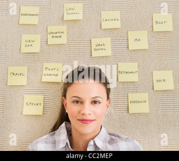 USA, New Jersey, Jersey City, Woman lying on carpet avec notes adhésives autour de chef Banque D'Images