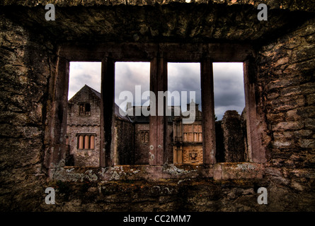 Vue à travers une fenêtre en pierre du château en ruines. Ruines médiévales du château de beaupré au Pays de Galles. Banque D'Images