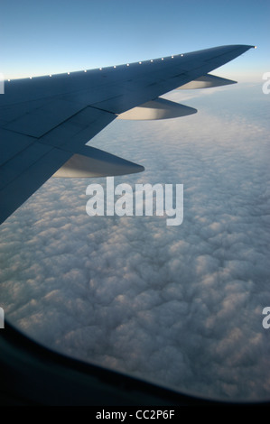 Jet liner volant au-dessus des nuages au lever du soleil . Banque D'Images