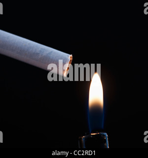 Close up of cigarette et des flammes de briquet sur fond noir Banque D'Images