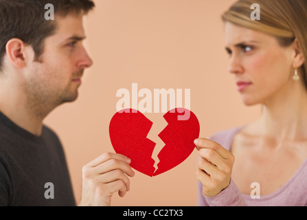 Couple holding red papier coeur brisé Banque D'Images