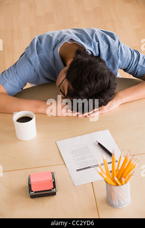 USA, Californie, Los Angeles, Businessman resting head on desk Banque D'Images