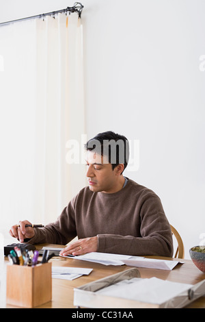 USA, Californie, Los Angeles, Man doing paperwork at home Banque D'Images