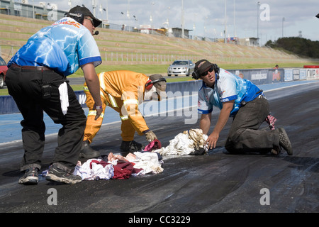 Piste de course les travailleurs de l'équipe de nettoyage de la marée noire à une course de glisser. Banque D'Images