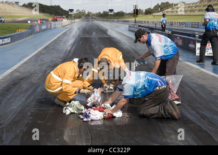 Piste de course les travailleurs de l'équipe de nettoyage de la marée noire à une course de glisser. Banque D'Images