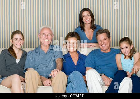 Portrait de deux génération famille avec deux filles (8-9, 14-15) sitting on sofa Banque D'Images