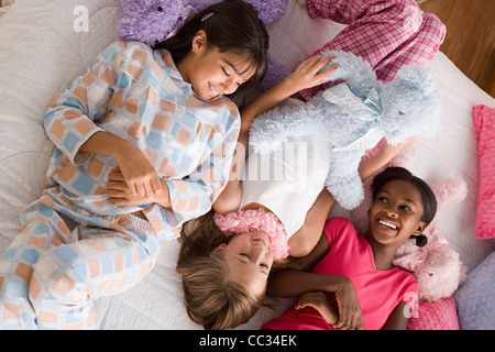 USA, Californie, Los Angeles, trois jeunes filles (10-11) lying on bed at slumber party Banque D'Images