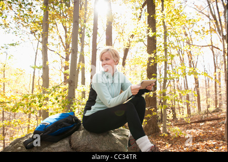 USA (New Jersey), Female hiker using digital tablet in forest Banque D'Images