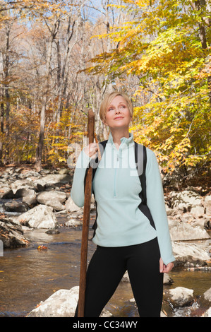 USA (New Jersey), Female hiker debout par stream in forest Banque D'Images